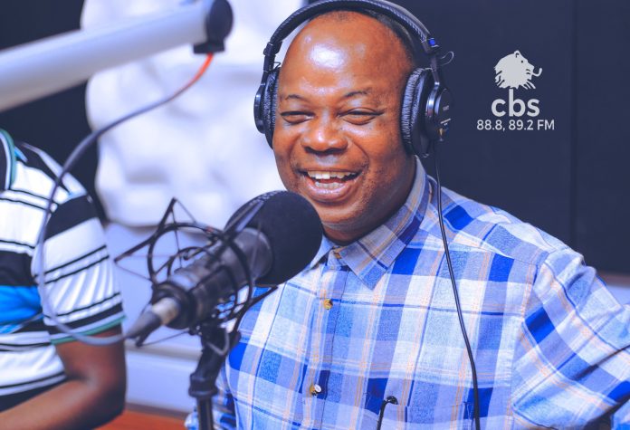 Meddie Nsereko Ssebuliba hosting a live radio show at CBS Uganda, engaging with political topics on air